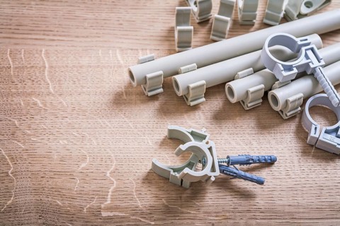 Aerial View Big Composition Polypropylene Fixators And Pipe With Clips On Wooden Board
