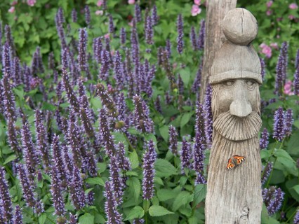Wooden sculpture surrounded by lavender with butterfly in blooming garden, papenburg, germany