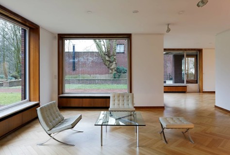 Interior (living room with retractable windows) of Haus Lange with a view of the garden to the east