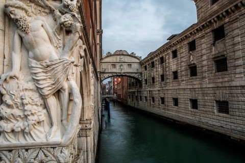 Stone sculpture of an ancient deity, Bridge of Sighs or Ponte dei Sospiri at the Doge's Palace over