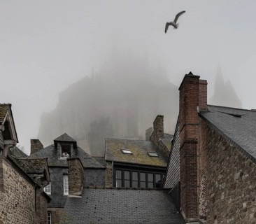 Mont-Saint-Michel, monastery hill, Grand Rue, roofscape above the abbey in the mist