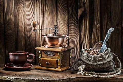 Coffee accessories brown clay cup vintage wooden mill and sack with beans scoop on old wood