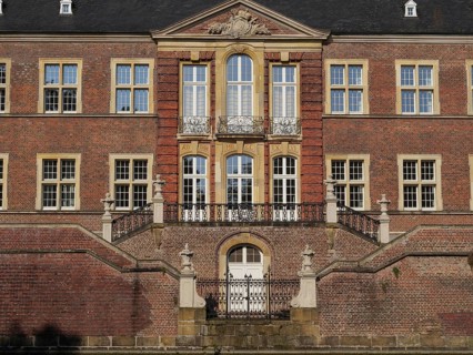 Magnificent red brick castle façade with ornate windows and symmetrical staircase, ahaus,