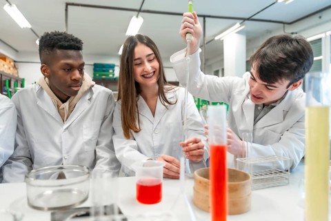 University students in lab coats conducting a chemistry experiment, using lab equipment and