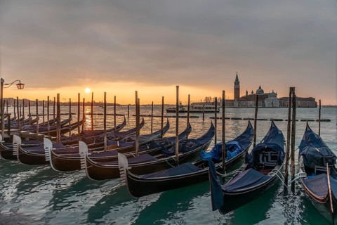 Cloudy atmosphere at sunrise, gondolas, San Giorgio Maggiore church in the background, Venice,
