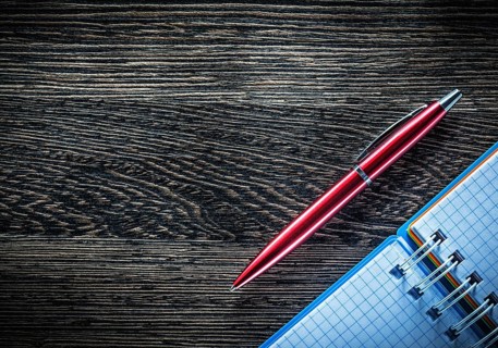 Biro pen spiral checked notebook on vintage wooden board