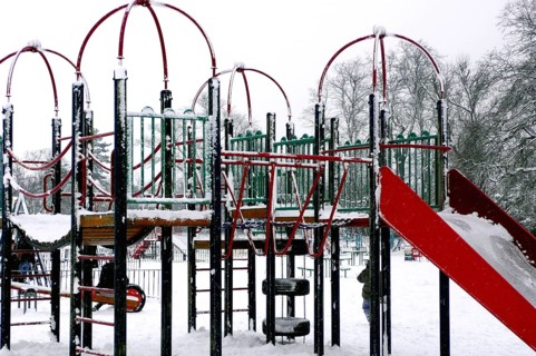 Snowstorm covering playground in park, London, UK United Kingdom England