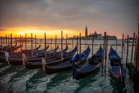 Cloudy atmosphere at sunrise, gondolas, San Giorgio Maggiore church in the background, Venice,