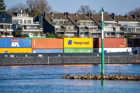 Container cargo ship on the Rhine near Düsseldorf-Bockum, villas on the banks of the Rhine, the