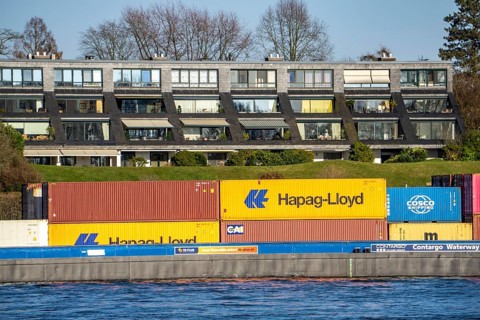 Container cargo ship on the Rhine near Düsseldorf-Bockum, villas on the banks of the Rhine, the