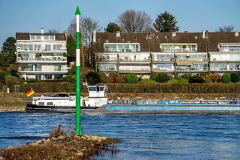 Cargo ship on the Rhine near Düsseldorf-Bockum, villas on the banks of the Rhine, the neighbourhood