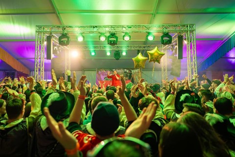 Lively concert with a cheering crowd under green spotlights, carnival, Schlagerkuchen Donzdorf,