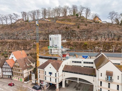 Cityscape with construction site, concrete tower, crane and surrounding historical architecture,