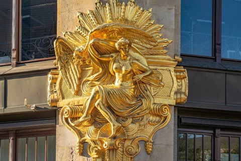 Gilded façade element with the allegory of hedonism on the former Art Nouveau department stores'