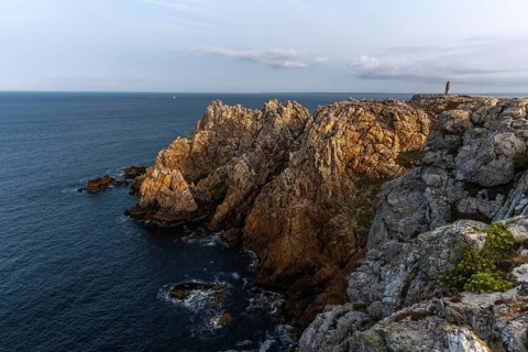 The tip of Pen Hir. The rocks are jagged and rough, the water is calm. The scenery is peaceful.