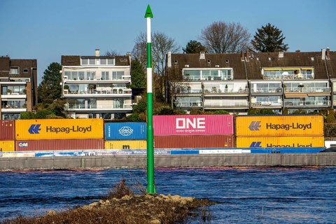 Container cargo ship on the Rhine near Düsseldorf-Bockum, villas on the banks of the Rhine, the