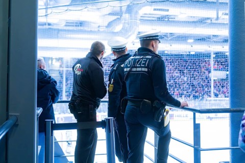 Three police officers monitor the action in an ice hockey stadium, Heilbronner Falken Vs