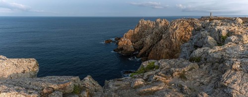 The tip of Pen Hir. The rocks are jagged and rough, the water is calm. The scenery is peaceful.