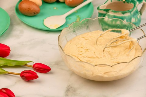 Finished dough in a bowl with ingredients in the background