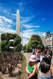 Tourists photograph themselves in front of the plant gates in the shape of the letters of Buenos