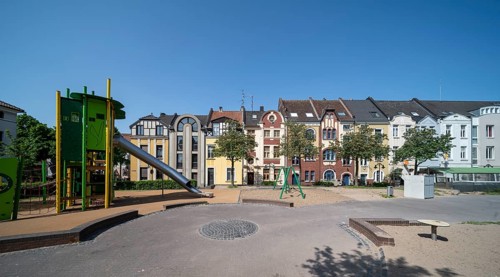 Krefeld, row of houses and playground at Anne-Frank-Platz