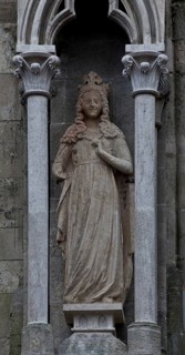 Sculpture of a crowned virgin in the left buttress canopy on the north side of the three western