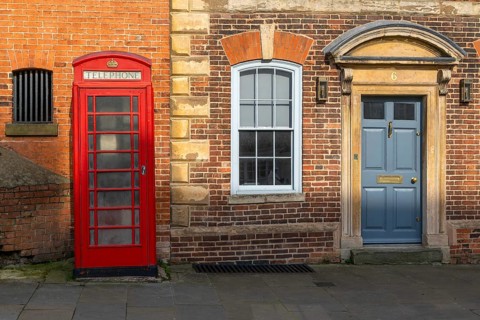 Traditional K6 red phone box and historic Houston Castle Hill, city of Lincoln, Lincolnshire,