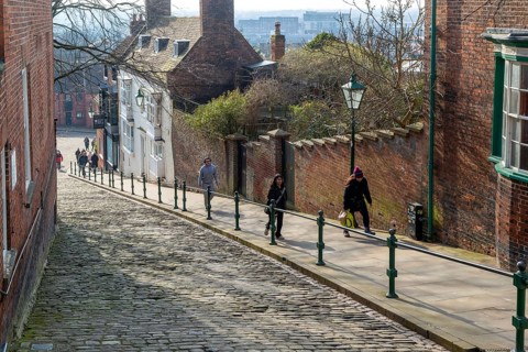People walking up Steep Hill cobbled street, Lincoln, Lincolnshire, England, UK