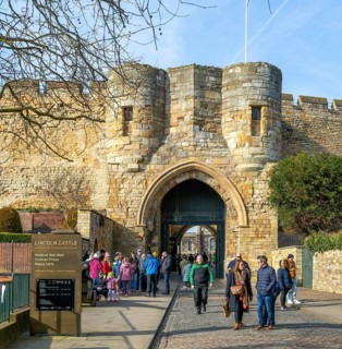 People outside entrance gateway to Lincoln castle, city of Lincoln, Lincolnshire, England, UK