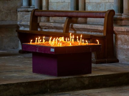 Lit candles burning inside cathedral, city of Lincoln, Lincolnshire, England, UK