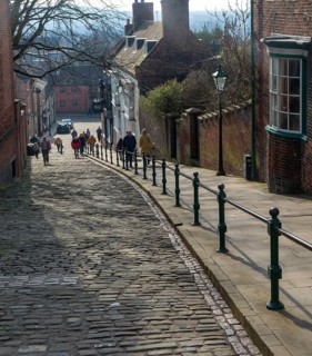 People walking up Steep Hill cobbled street, Lincoln, Lincolnshire, England, UK