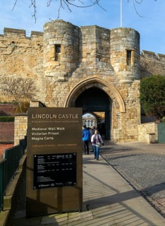 People outside entrance gateway to Lincoln castle, city of Lincoln, Lincolnshire, England, UK