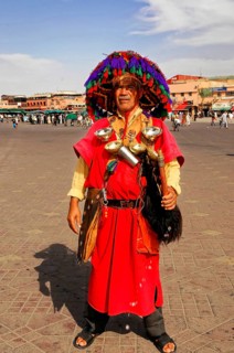 Water vendor, A man in traditional Moroccan clothing with a colourful hat stands in a square in