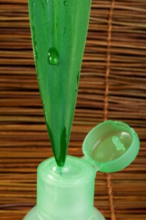 Green cosmetic bottle, green leaf and drop