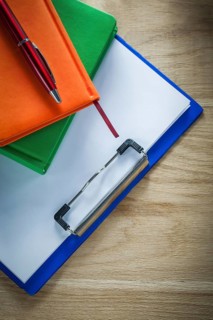 Clipboard notepad ballpoint pen on wooden board
