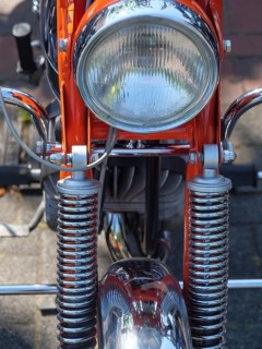 Frontal view of an orange motorbike with shiny chrome headlight, Appelhülsen, münsterland, germany