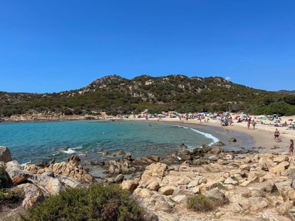 Lively beach with people and blue water, cagliari, sardinia, italy