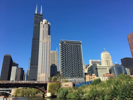 Various skyscrapers and modern architecture along a river under a clear sky, chicago, illinois, usa