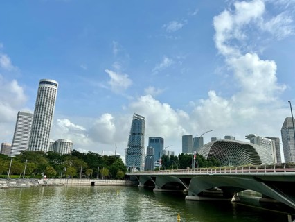 Modern skyscrapers and bridge on the riverside with blue sky and scattered clouds, singapore