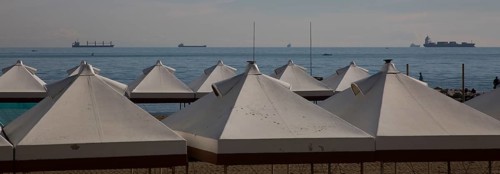 Italy Venice Lido -10 beach tents at the back of the Adriatic Sea with cargo ships in the roadstead