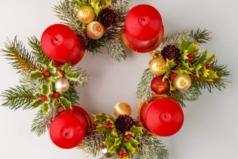 Round Advent wreath with red candles and Christmas decorations, from above
