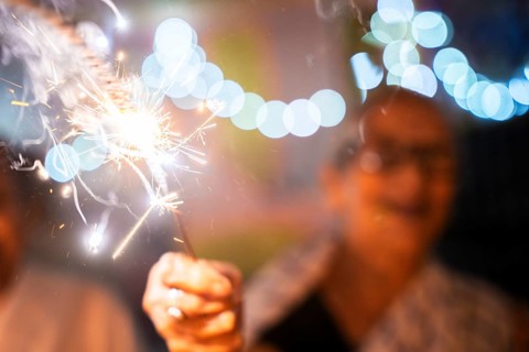 An elderly woman of Pramod Talukdar Memorial Old Age Home burn sparkler crackersas she celebrate