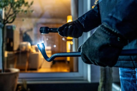 Symbolic image of a burglary, perpetrator spies on a flat from the garden side