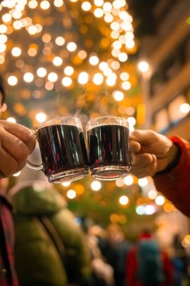 Two cups of mulled wine are toasted in a festive and illuminated night, Lichternacht Fest, Nagold,