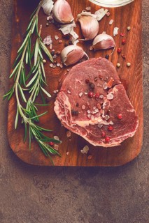 Fresh, raw rib eye steak, on a chopping board, top view, no people