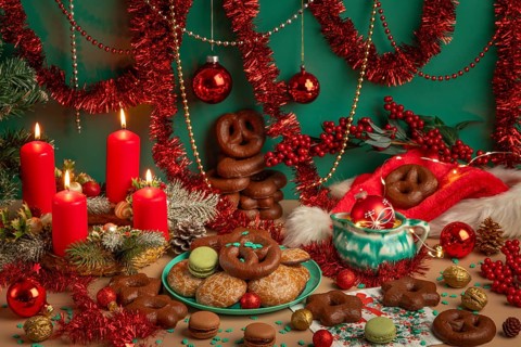 Lavishly decorated table with Christmas decorations, Advent wreath with four lit candles and