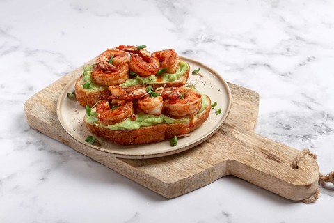 Sandwiches with avocado and caramelized shrimp, micro-greens, breakfast, on a plate, top view,