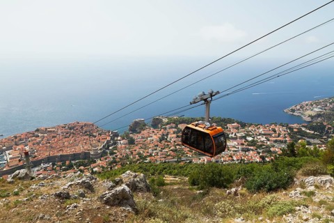 High angle view of cable car transporting tourists from top of Mount Srd down to Dubrovnik city