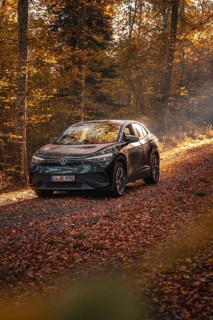 Car in an autumnal forest illuminated by sunbeams, calm atmosphere, electric car VW ID5, Gechingen,
