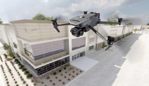 Unmanned aircraft system quadcopter drone UAV in the air near corporate industrial building